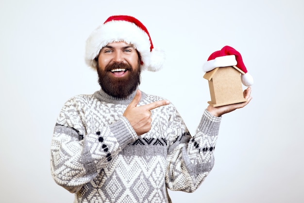 幸せな顔にひげを持つクリスマスの男は贈り物を保持します