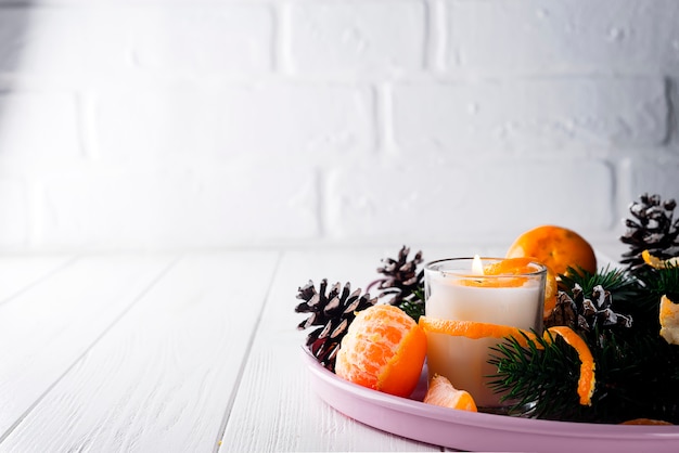 Christmas mandarines with lighted candle.