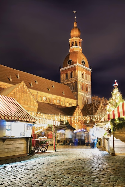 Christmas market at the Dome square near the Riga Cathedral in old Riga, Latvia. It is the oldest Medieval church in Baltic states. Motion blur. Selective focus