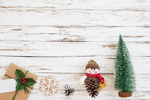 Albero in miniatura di natale, decorazione di natale e confezione regalo su fondo di legno bianco. stile vintage, vista dall'alto.