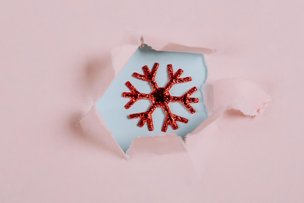 引き裂かれた紙の穴のフラットスタイルのテキストのトップビューの場所でクリスマスミニマルコンセプトスノーフレーク