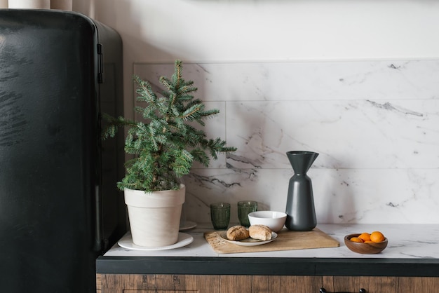 Christmas minimalistic fir tree in a ceramic pot in the decor of the kitchen