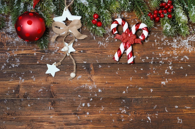 Christmas mock-up with fir tree branches and red and golden decorations on the wooden table