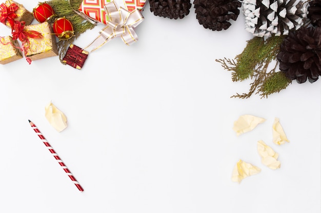 クリスマスモックアップ。クリスマスプレゼント、松のコーン、木製の白い背景。上面図、コピー間隔