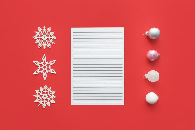 Foto modello di natale con blocchi di nota bianchi aperti, fiocchi di neve e ornamenti di natale in argento bianco