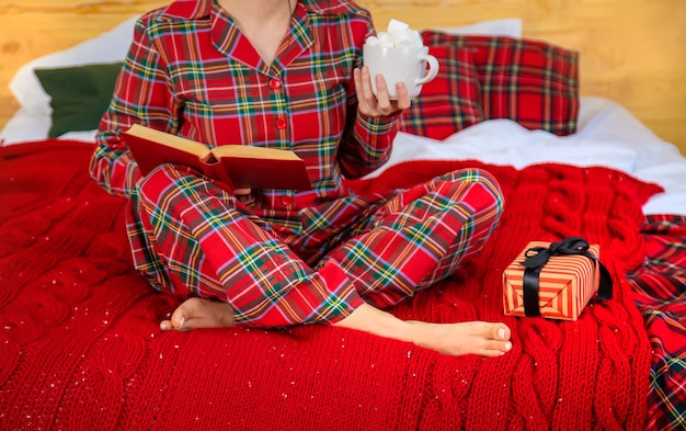 Christmas morning, girl in pajamas with a book. Selective focus. Holiday.