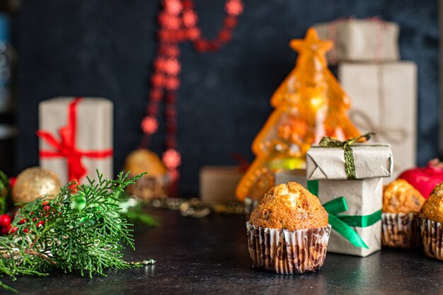 Christmas muffins with decorations on black table