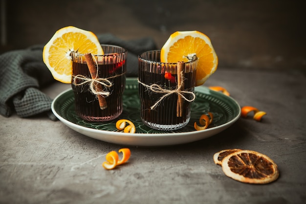 Christmas mulled red wine with aromatic spices and citrus fruits in wooden box, close-up. Traditional hot drink at Christmas time