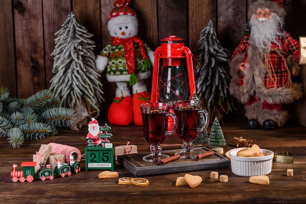 Christmas mulled red wine with spices and fruits on a dark table.