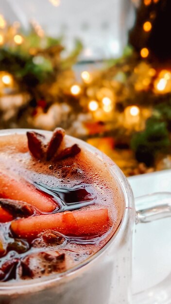 明るい光の背景をぼかした写真にクリスマスホットワインを作った伝統的な新年のホットドリンク