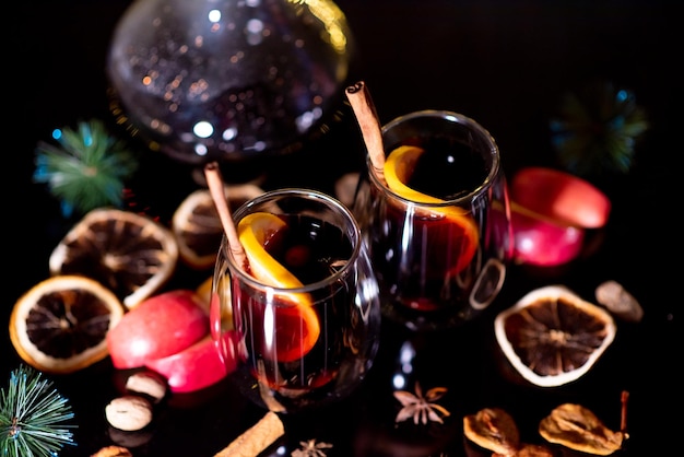 Photo christmas mulled wine of red wine with spices and fruits on a black background christmas