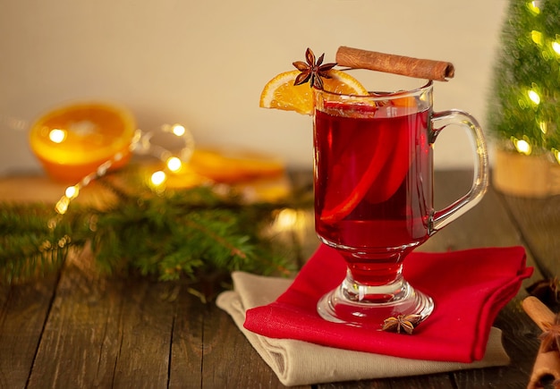 Christmas mulled wine red wine with spices and fruits on a wooden rustic table. Traditional hot drink for Christmas.Horizontal frame