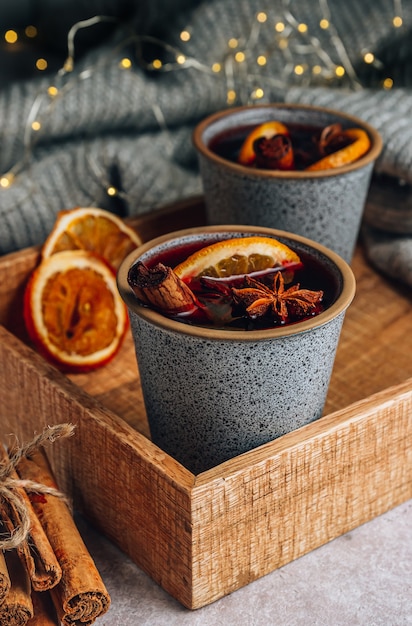 Christmas mulled wine. winter cozy composition with two cup on\
wooden tray