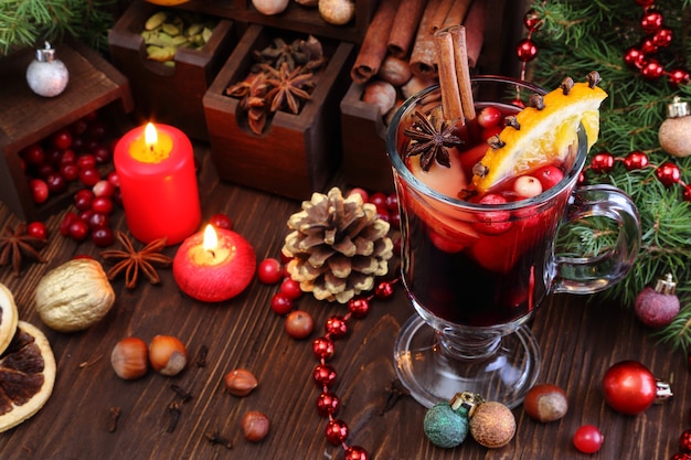 Christmas mulled wine with apple cranberry orange and spices on a wooden table