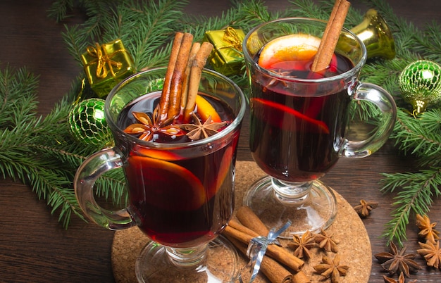 Christmas mulled wine with cinnamon and orange. On the table are spruce twigs and toys