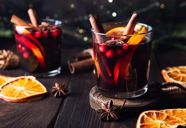소박한 나무 배경에 크랜베리 오렌지와 향신료를 곁들인 크리스마스 mulled 와인