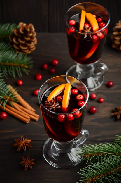 오렌지와 크랜베리 크리스마스 mulled 와인입니다. 휴일 개념 전나무 가지와 향신료로 장식.