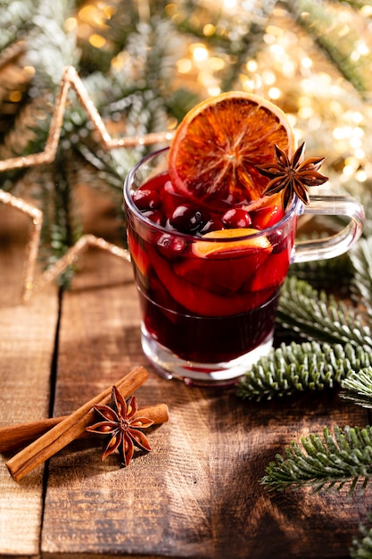 Christmas mulled wine with spices on a wooden rustic table.