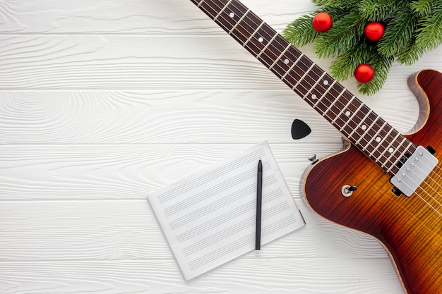 Composizione di musica di natale con chitarra e rami di abete