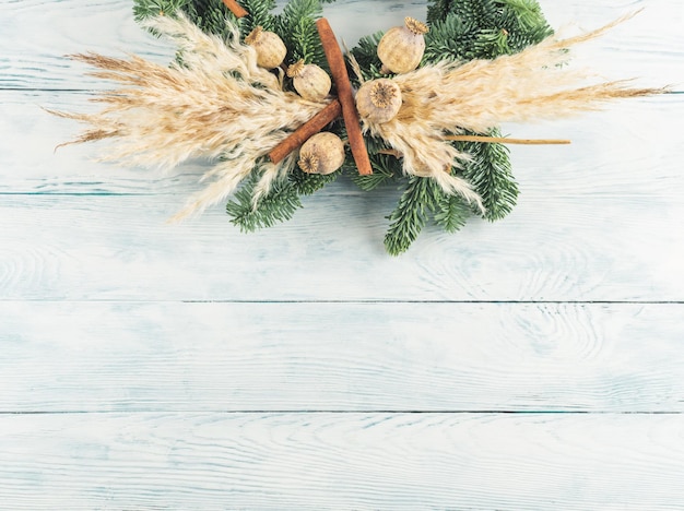 Christmas natural spruce wreath with dry decor pampas reed and cinnamon on wooden background