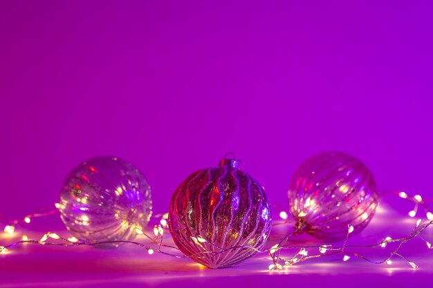 Christmas neon background with garland and Christmas balls copy space