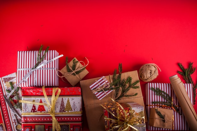 クリスマスと新年の背景。赤い背景にモミの枝で飾られたギフトボックス