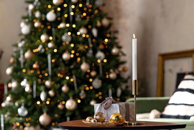 크리스마스와 새해 배경 - 선물 상자, 선물, 양초, 장식된 크리스마스 트리의 보케 조명 배경. 부드러운 선택적 초점입니다.