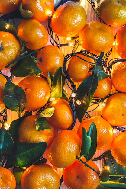 Christmas New Year background of tangerines and burning garlands.