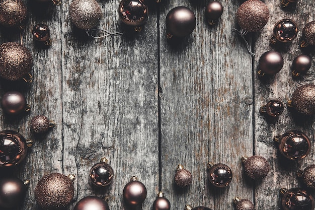 Christmas or New Year background. Vintage Christmas tree toy decoration balls and light garland over rustic wooden background, selective focus, copy space