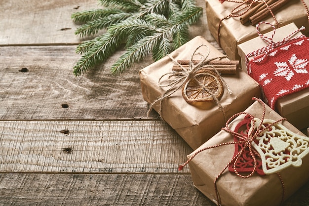 Sfondo di natale o capodanno con rami di abete, palle di natale, confezione regalo, fiocchi di neve in legno e stelle su fondo di legno scuro. posto per il tuo testo