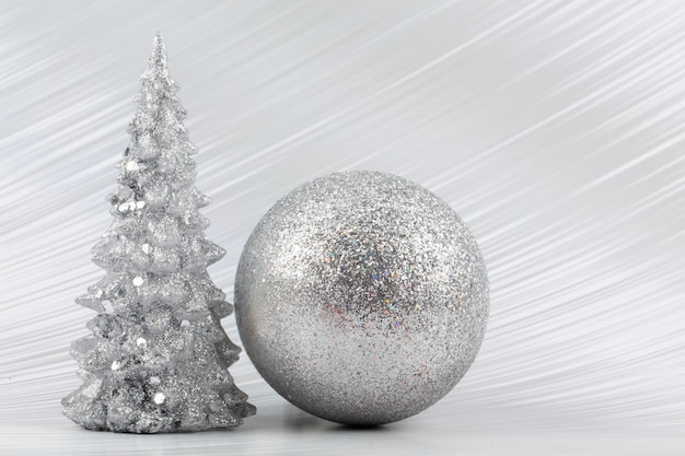 Photo christmas or new year background with silver snowy tree and silver transitional decoration