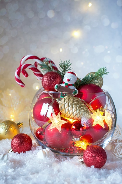 Рождество или Новый год яркие украшения в стеклянной вазе с леденцами на снегу