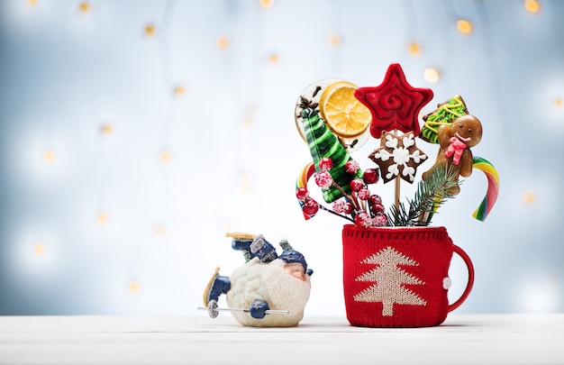 크리스마스 진저브레드와 사탕, 산타클로스가 나무 배경에 있는 크리스마스 또는 새해 카드. 겨울 방학을 위한 축제 장식과 선물.