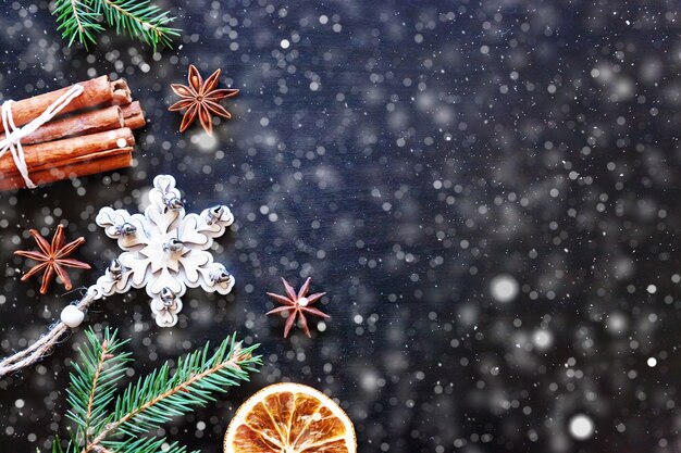 Christmas New Year Composition frame made of winter objects fir branch ornament cinnamon on dark black background