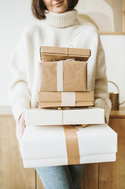 Foto composizione del nuovo anno di natale. vacanze invernali fatte a mano confezionano scatole regalo nelle mani della donna