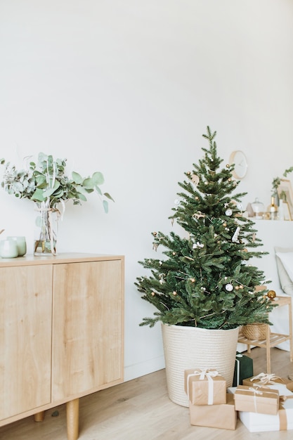 Christmas New Year composition. Living room with festive fir-tree decorated with toys, gifts, balls.