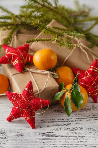 Christmas New Year composition with fir branches and orange tangerines on the old wooden table in country style, selective focus