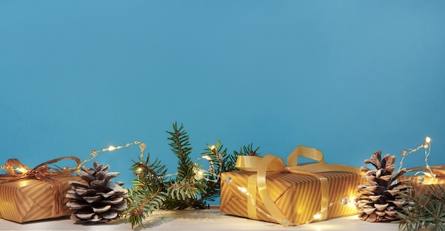 Рождественская или новогодняя композиция с золотыми елочными украшениями, подарками и огнями