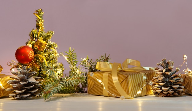 Рождественская или новогодняя композиция с золотыми елочными украшениями, подарками и огнями