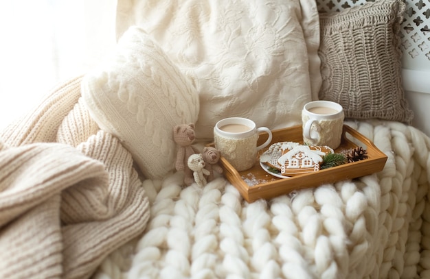 Photo christmas and new year composition with a soft plaid, pillows, cookies, gingerbread and coffee. cozy home and winter concept.
