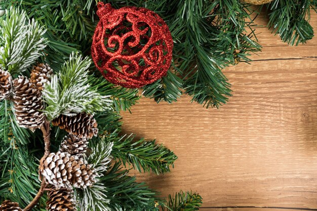 Рождественский новогодний состав на деревянном фоне стола. Еловые ветки, рождественские украшения. Плоская планировка, вид сверху, копия пространства.