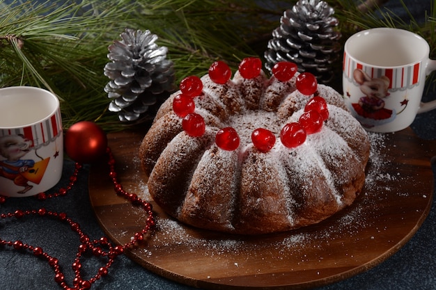 Christmas and New Year concept Delicious lemon cake with red sweet cherries and sugar powder