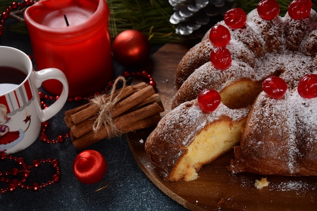 Christmas and New Year concept Delicious lemon cake with red sweet cherries and sugar powder