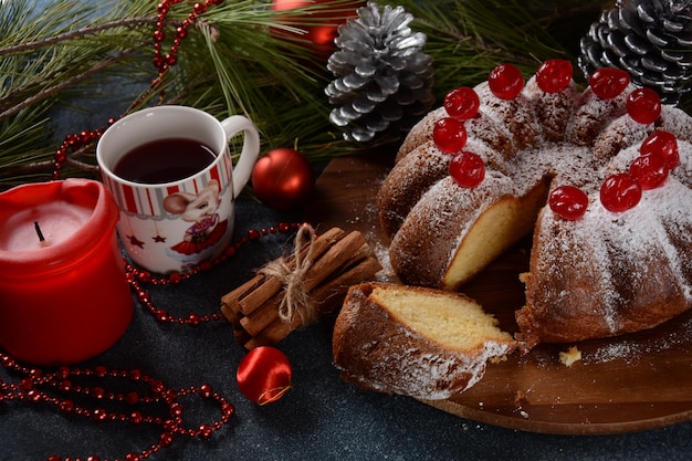 Christmas and New Year concept Delicious lemon cake with red sweet cherries and sugar powder