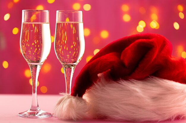 Christmas and new year concept with two glasses of champagne against bokeh lights