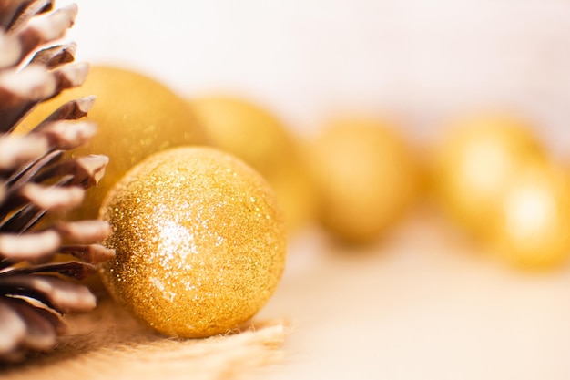 Christmas, New Year decoration, pinecones, shiny golden balls, blurred light background, copy space