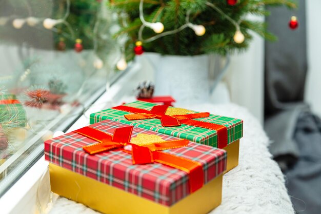 Christmas and new year decorations. gift boxes, fir branches, garland on the windowsill. cozy christmas. selective focus