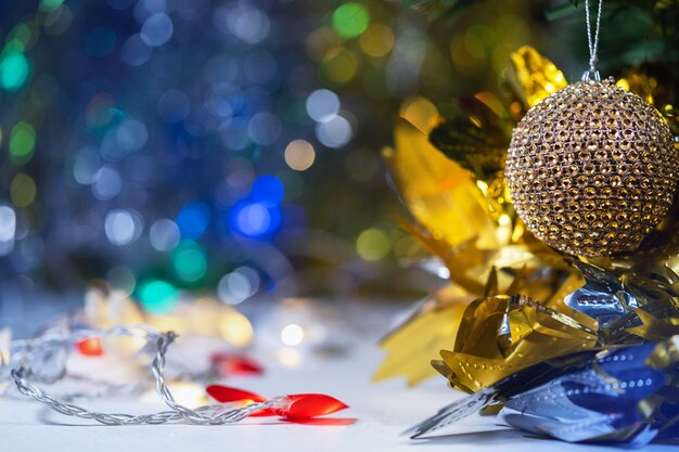 Christmas and new year decorations and illumination with a large golden ball in the foreground.