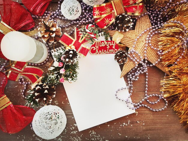 Foto composizione decorativa di natale e capodanno. vista dall'alto, sfondo con copia spazio per il testo. stella, coni, taccuino, candela, fiocchi su un tavolo di legno con la neve.