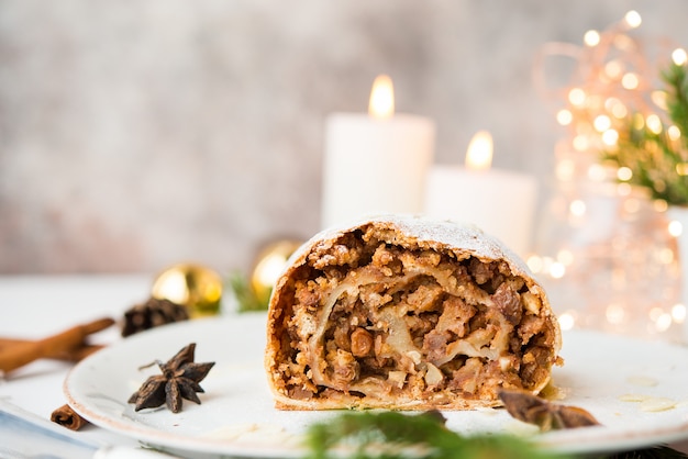 Christmas and new year dessert. Apple pie in festive decorations, with garlands and Christmas toys.